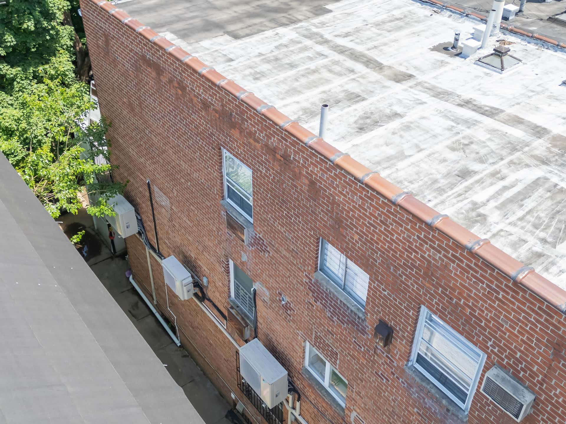 Aerial roof and parapet wall inspection documenting baseline conditions in an OpenDoors360 pre-construction survey in New York City.